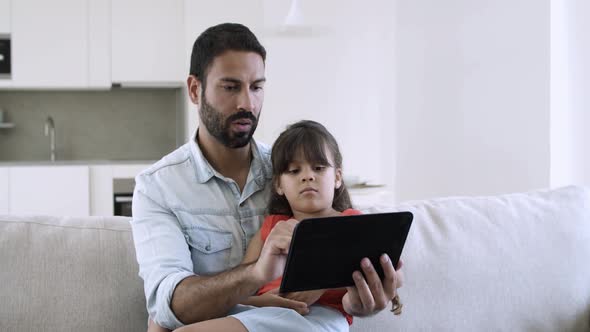 Dad and Cute Little Daughter Using Online App on Tablet