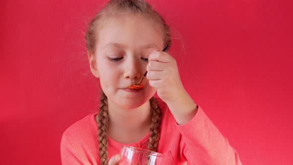 Child eating yogurt jelly pink background Dairy product diet Lactobacillus Acidophilus healthy food