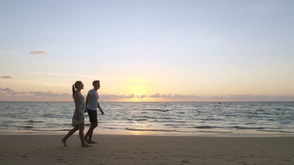 Cheerful Family Walks Along Empty Ocean Beach Joining Hands