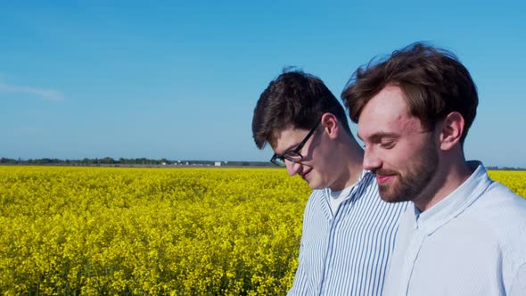 Two young guys in love admire each other in the field