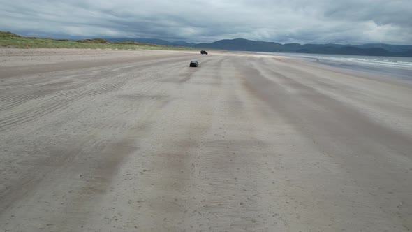 Car driving on Inch beach Dingle peninsula Ireland drone aerial view