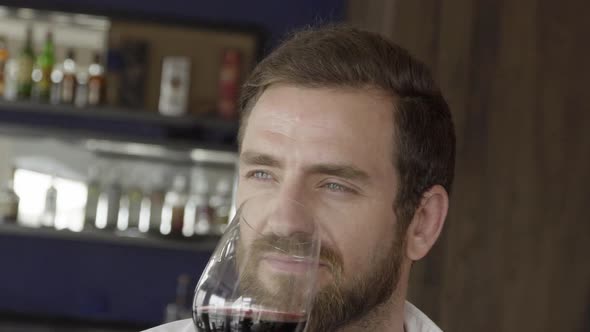 Slow motion shot of man tasting glass of red wine