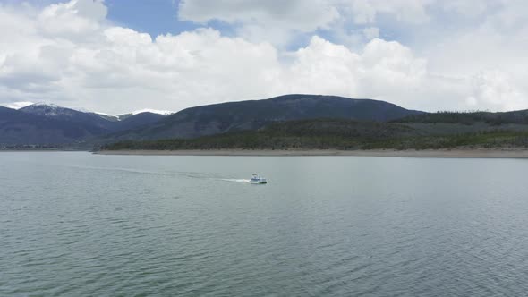 Aerial Flyby Shot of a Lone Party Boat on a Beautiful Mountain Lake in Colorado (Dillon Reservoir)