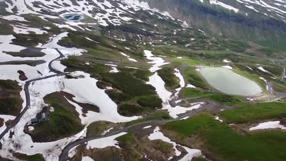 Drone shot of a Ski Resort in the Summer with a Water Reserve and Patches of Snow