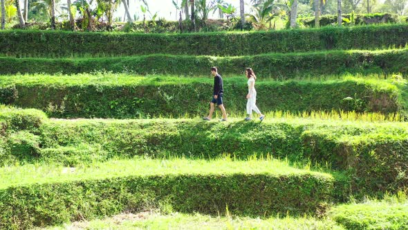 Tourist Couple Walking On The Banaue Rice Terraces in the Philippines On A Sunny Day - Medium Shot