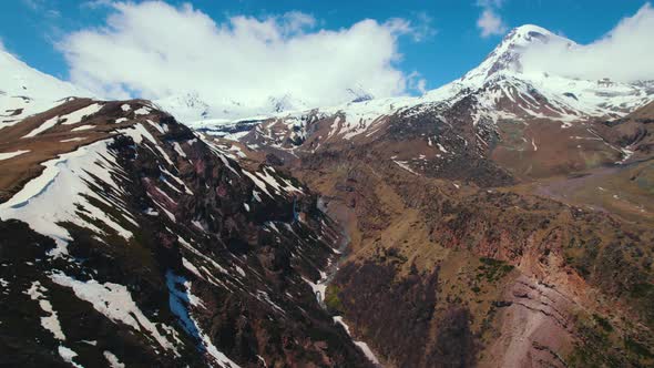 Scenic Drone Shot of the Snowy Caucasus Mountains and Mkinvartsveri Kazbegi Georgia