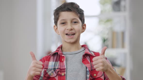 Charming Cute Boy Showing Thumbs Up Looking at Camera and Smiling