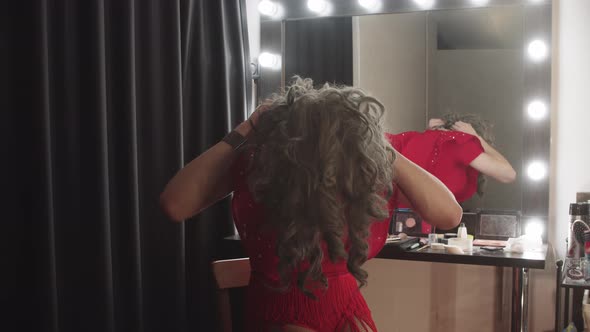 A Young Man Drag Artist Puts on a Wig Behind the Scenes