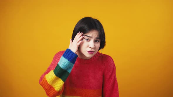 Young Cute Woman in Red Sweater with Rainbow Sleeves Looking at Camera with Question and Showing