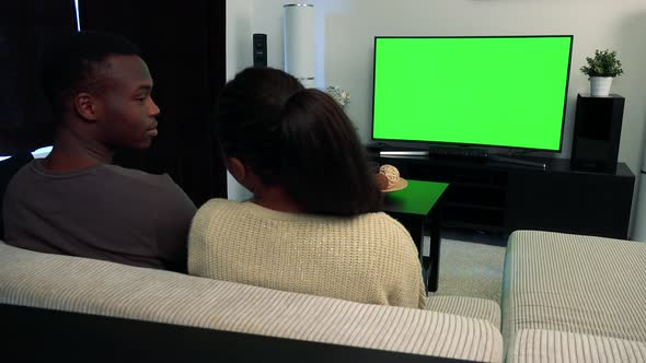 Young Black Unhappy Couple Watch Television in Living Room and They Argue