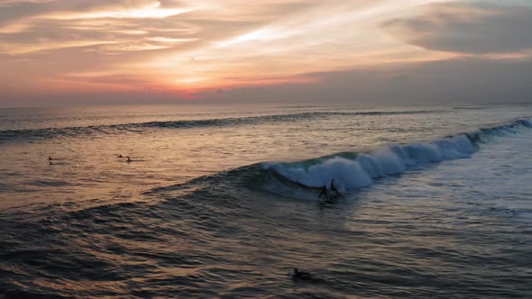 Aerial View of Surfer Riding Sunset Ocean Wave. Drone  Shot Surfing Ocean Lifestyle, Extreme Sports.