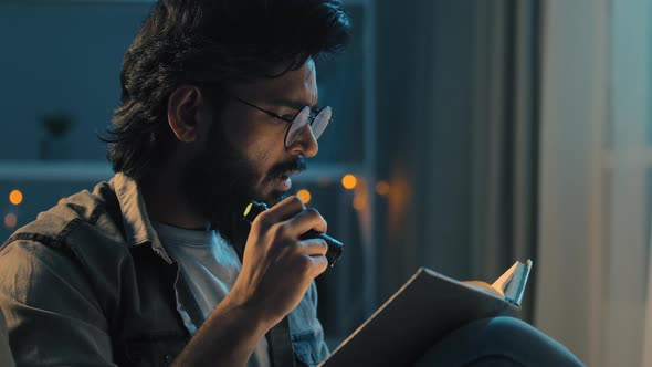 Arab Indian Adult Man with Beard Wearing Glasses Sitting at Home Night Late Time Darkness Blackout