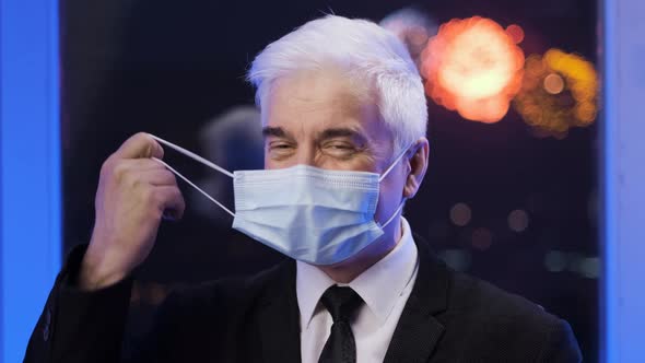 Happy Cured Grey Businessman Takes Off Corona Virus Mask