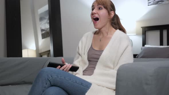 Excited Woman Reacting to Success Watching TV