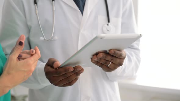 Doctor and Nurse in Medical Hospital Discuss Prescription Report on Digital Tablet Spbas
