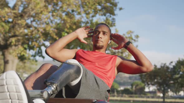 Side view man with prosthetic leg doing abs