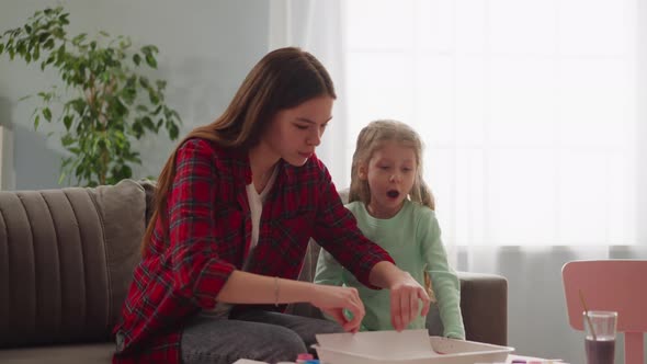 Amazed Girl Looks at Picture in Erbu Style with Elder Sister