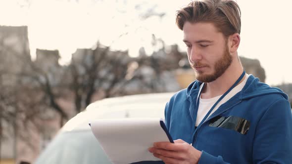 Delivery Driver Checking His List of Parcels