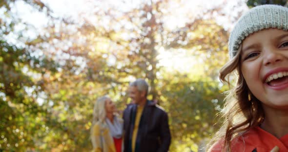 Smiling girl with happy parents in backgrounds