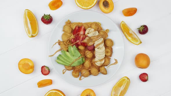 Waffles Decorated with Fruits and Berries on a White Wooden Background Top View