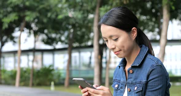 Woman using cellphone at outdoor park 