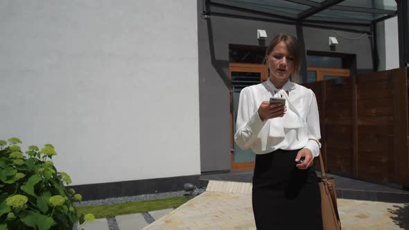 Busy Woman Using Smartphone Walking To Car