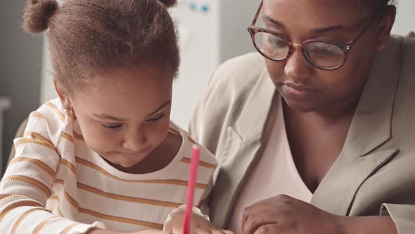 African-American Girl Studying with Teacher in Class