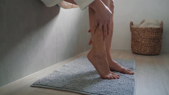 Unrecognizable caucasian woman applying moisturizing cream on legs. Shot with RED helium camera in 8