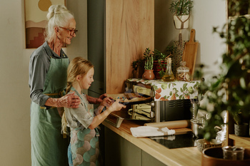 Grandmother Guiding Granddaughter with Baking Cookies