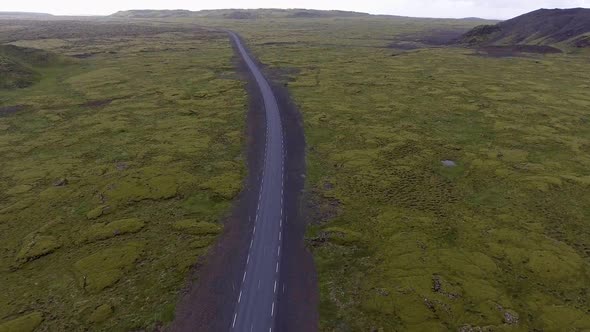 Aerial View of Road Through Mossy Lava Field in Iceland