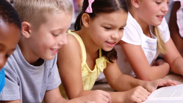 School kids reading book in library