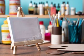 small wooden easel with blank canvas on wooden table