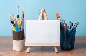 small wooden easel with blank canvas on wooden table