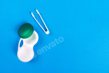 Container for contact lenses and tweezers on Blue background