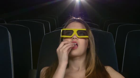 Young Girl in Horror Film 3D at the Cinema. Eating Popcorn. Close Up