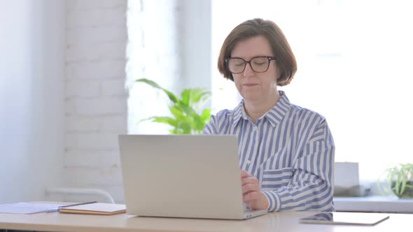 Senior Woman Thinking While Working on Laptop