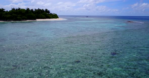 Wide birds eye tourism shot of a sunshine white sandy paradise beach and blue water background in co