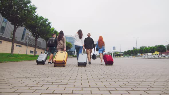 Five Traveling Friends Head To the Airport Terminal with Luggage in Hand. Tourists and Travelers Go