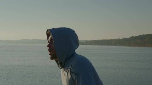 Young Man Is Running Near Lake