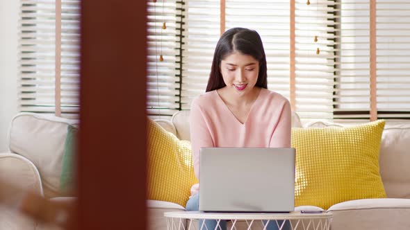 business asian young woman wear Pink Sweater work online with laptop