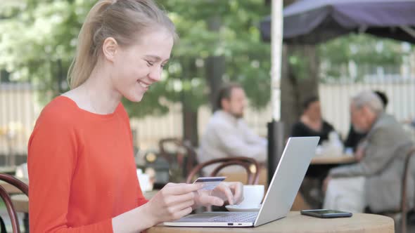 Successful Online Shopping by Young Woman Sitting on Bench