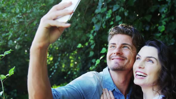 Romantic couple taking selfie from mobile phone in park