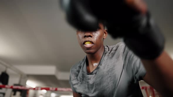 Motivational Sport Portrait of African Man Boxer Throwing Punches During Training in Boxing Club