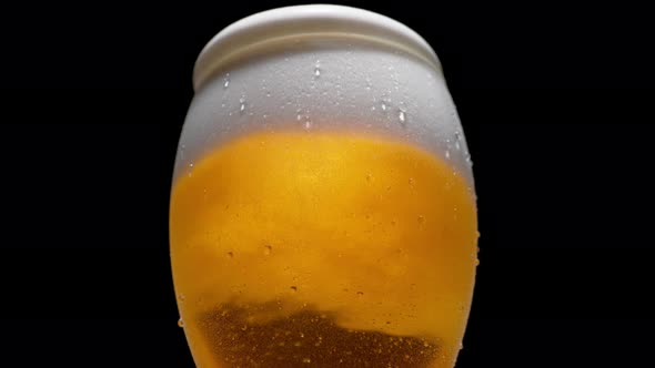Close-up beer in glass. Foam overflowing. Slow Motion. alt