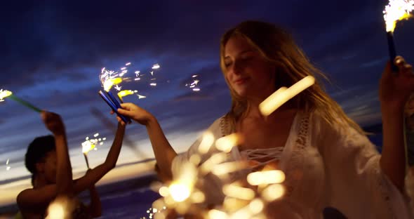 Friends playing with sparklers on the beach 4k