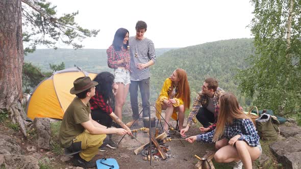 Active Young Tourists Enjoying Preparing Mushrooms Outdoors.