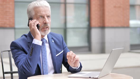 Angry Old Businessman Talking on Phone