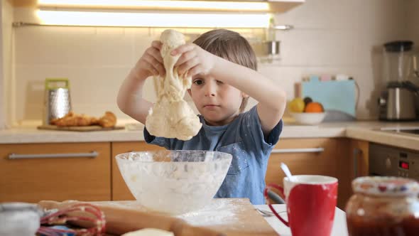 Cute Little Boy Playing and Having Fun with Soft Dough for Biscuits on Kitchen