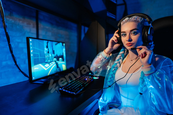 A young woman with colorful braids plays video games in a modern gaming setup