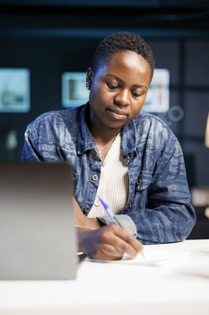 Freelancer uses pen to write on notebook